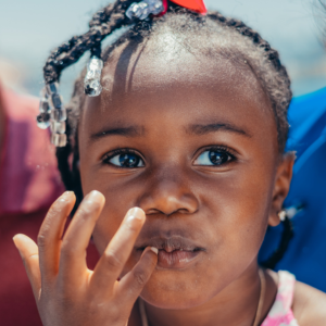 Little girl putting her fingers to her mouth